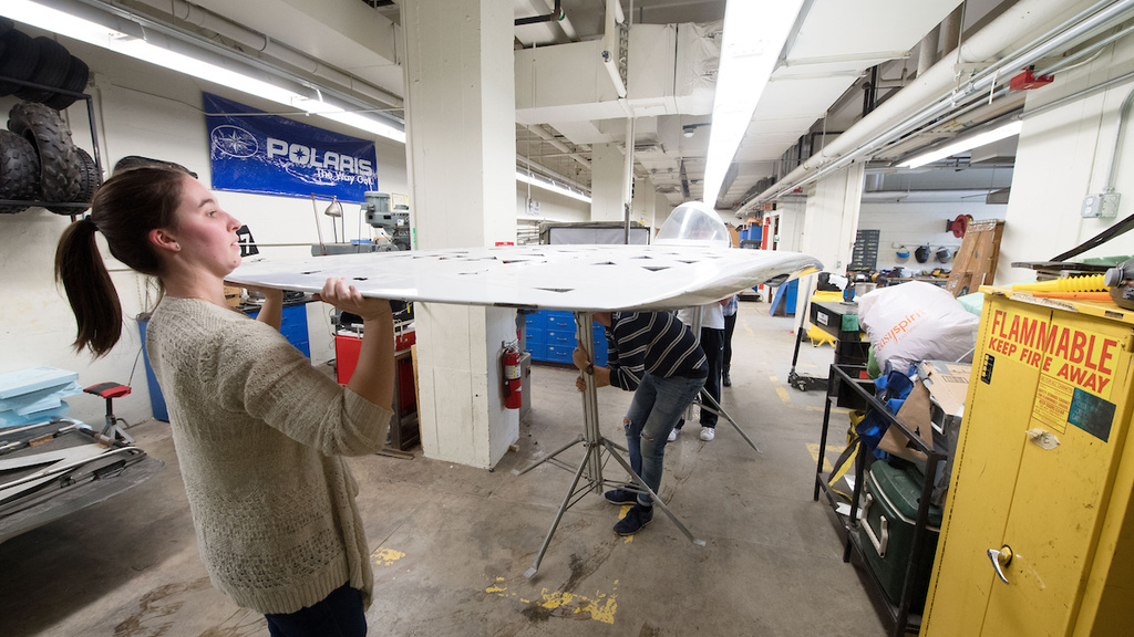 Students carry part of a solar car